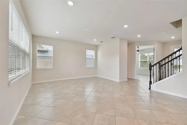 an empty room with a window and a fan