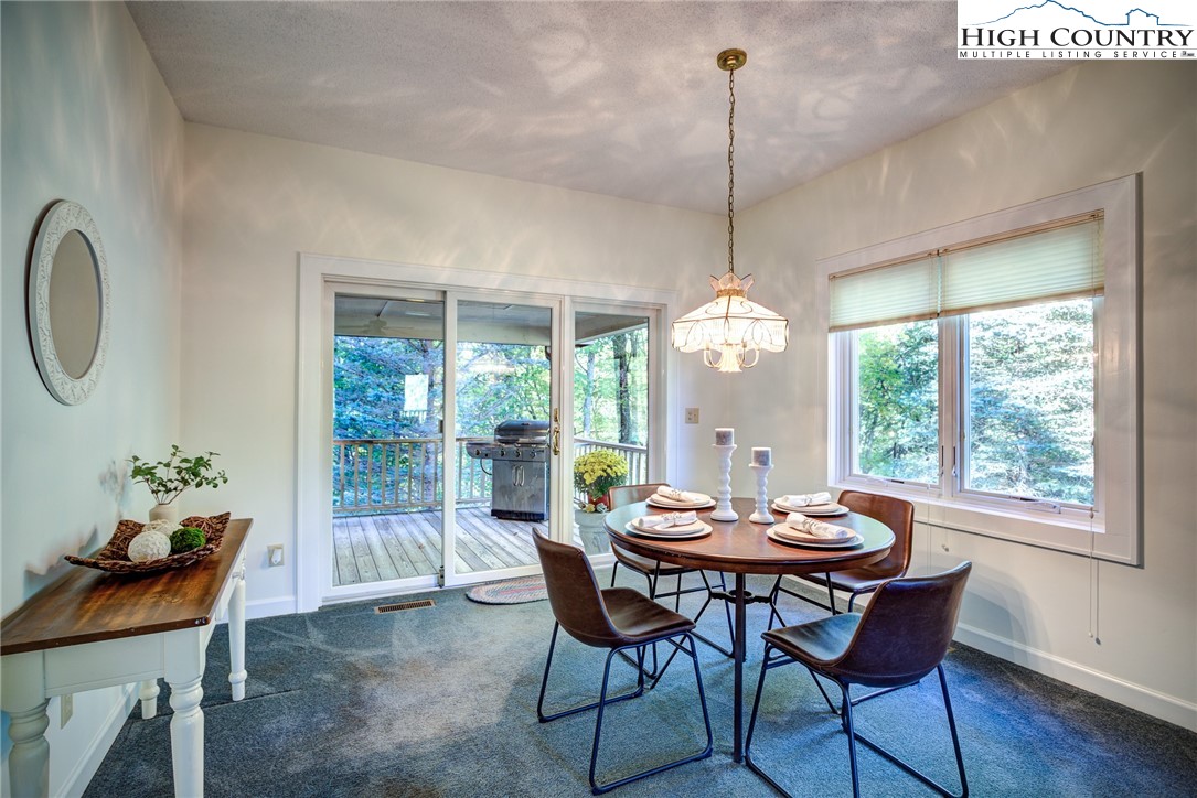 1267 Hopewell Church Road Boone, NC 28607 - Photo 17 of 50 a dining room with furniture a chandelier and wooden floor