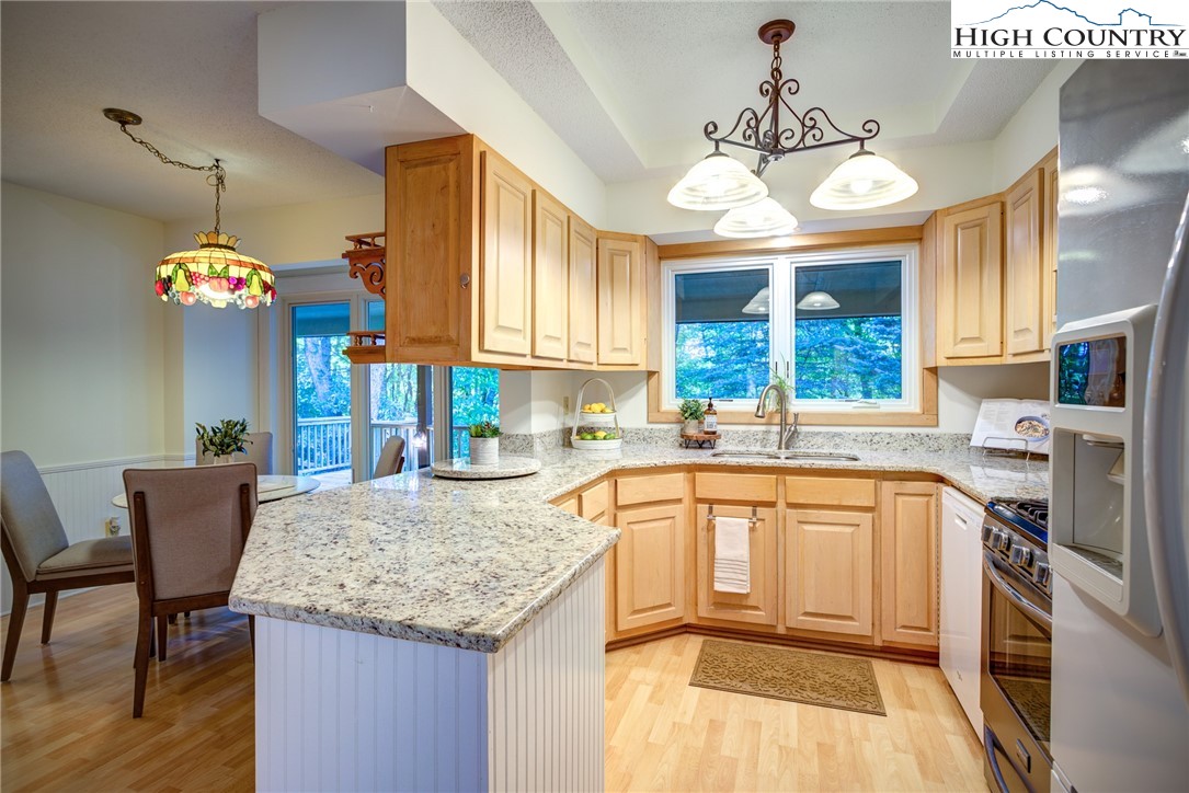 1267 Hopewell Church Road Boone, NC 28607 - Photo 20 of 50 a kitchen with granite countertop a stove a sink a dining table and chairs