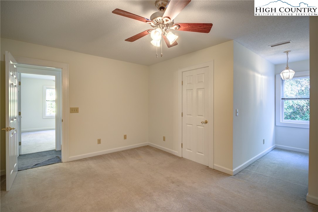 1267 Hopewell Church Road Boone, NC 28607 - Photo 30 of 50 an empty room with a chandelier fan and windows