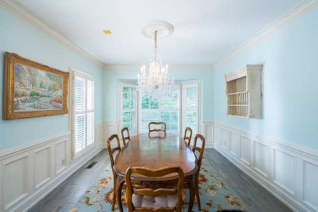 a dining room with furniture a chandelier and wooden floor