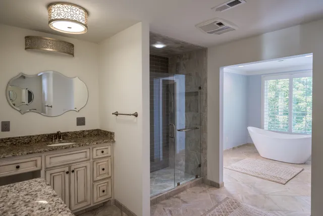 a spacious bathroom with a granite countertop sink and a mirror