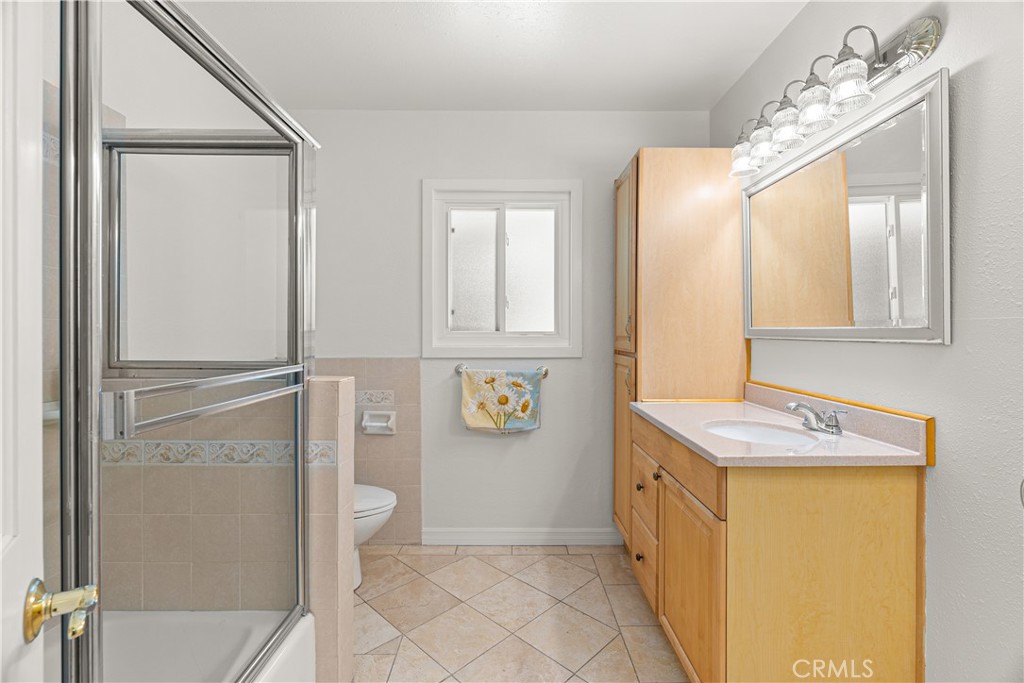 591 Busch Place Pasadena, CA 91105 - Photo 20 of 64 a bathroom with a granite countertop sink a mirror and shower