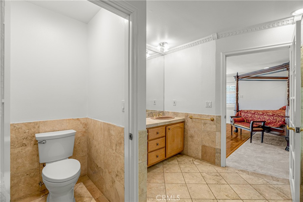 591 Busch Place Pasadena, CA 91105 - Photo 45 of 64 a bathroom with a granite countertop sink a toilet and a mirror