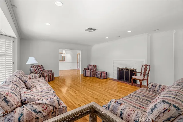 a view of an empty room with wooden floor and windows