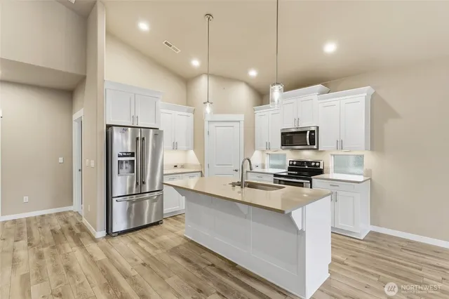 a kitchen with stainless steel appliances a refrigerator sink and microwave