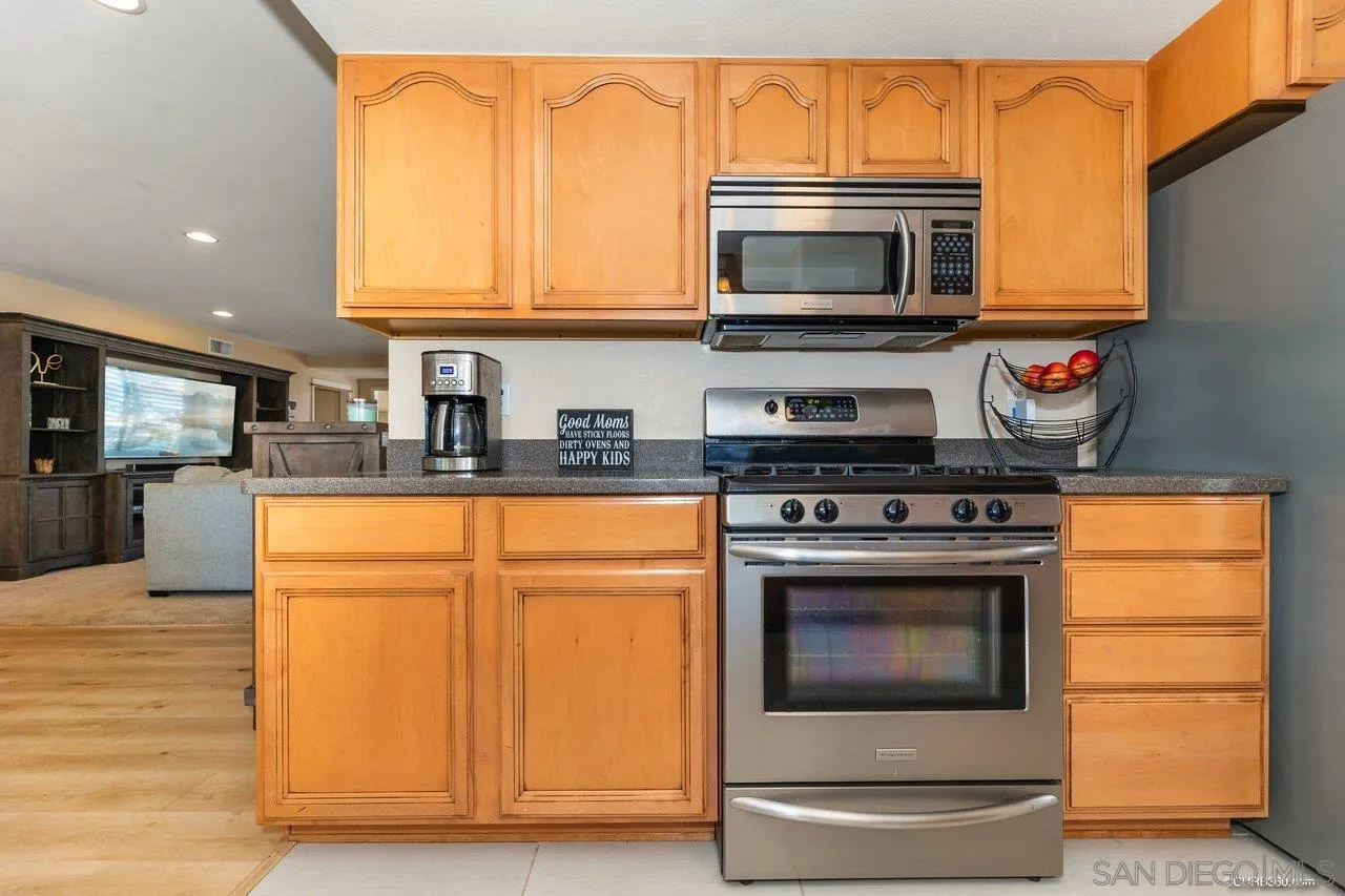 13317 Arikara Drive Poway, CA 92064 - Photo 18 of 52 a kitchen with stainless steel appliances granite countertop a stove microwave and refrigerator