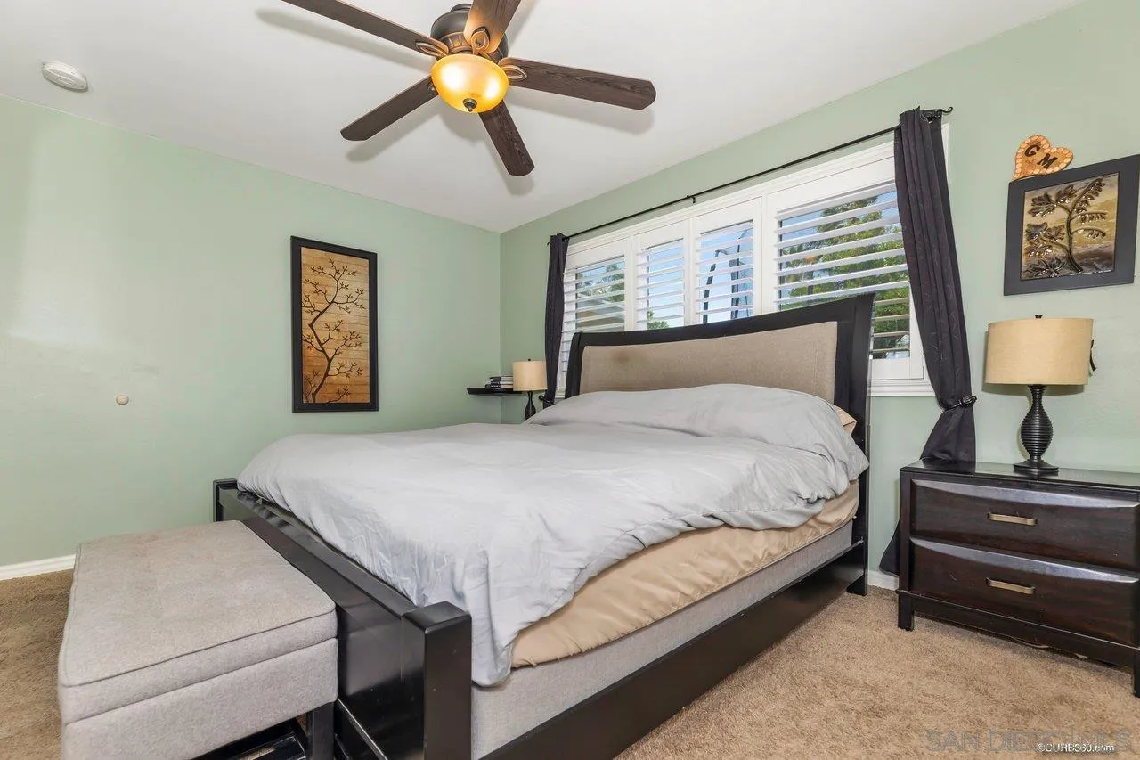 13317 Arikara Drive Poway, CA 92064 - Photo 37 of 52 a bedroom with a bed a lamp and a chandelier