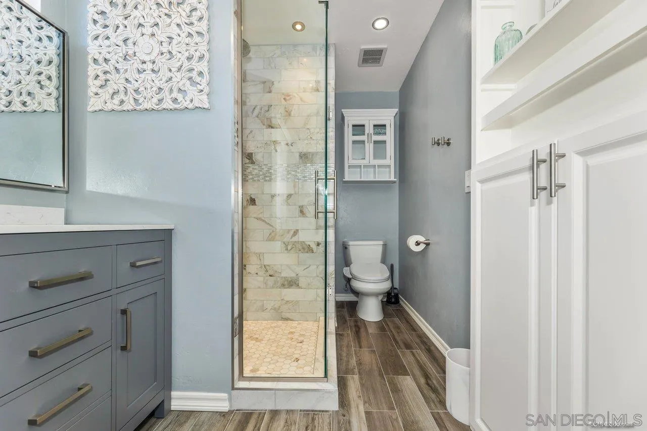 13317 Arikara Drive Poway, CA 92064 - Photo 40 of 52 a bathroom with a granite countertop sink a toilet and a shower