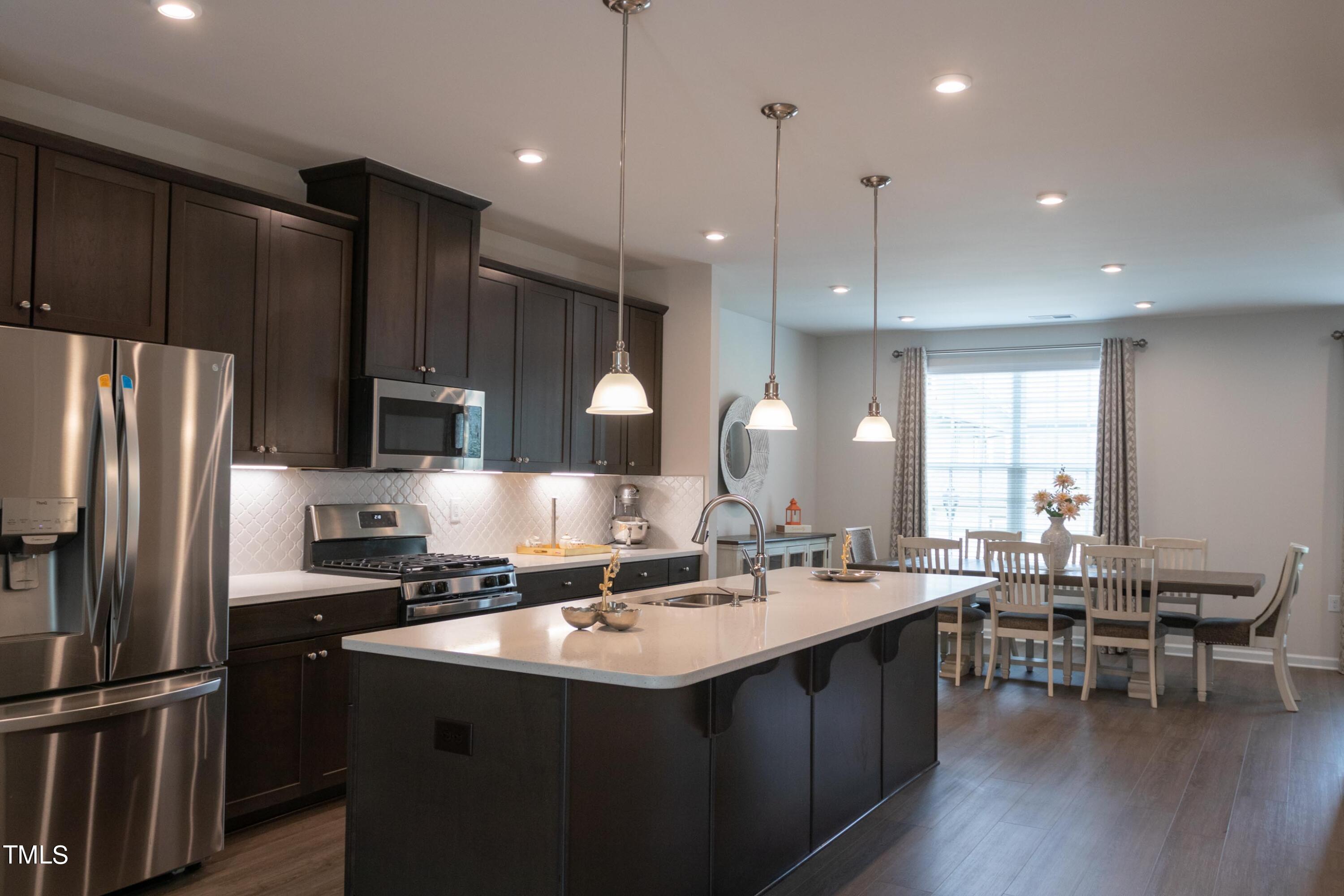 1505 Newpoint Drive Durham, NC 27713 - Photo 2 of 48 a kitchen with a sink stainless steel appliances and chairs
