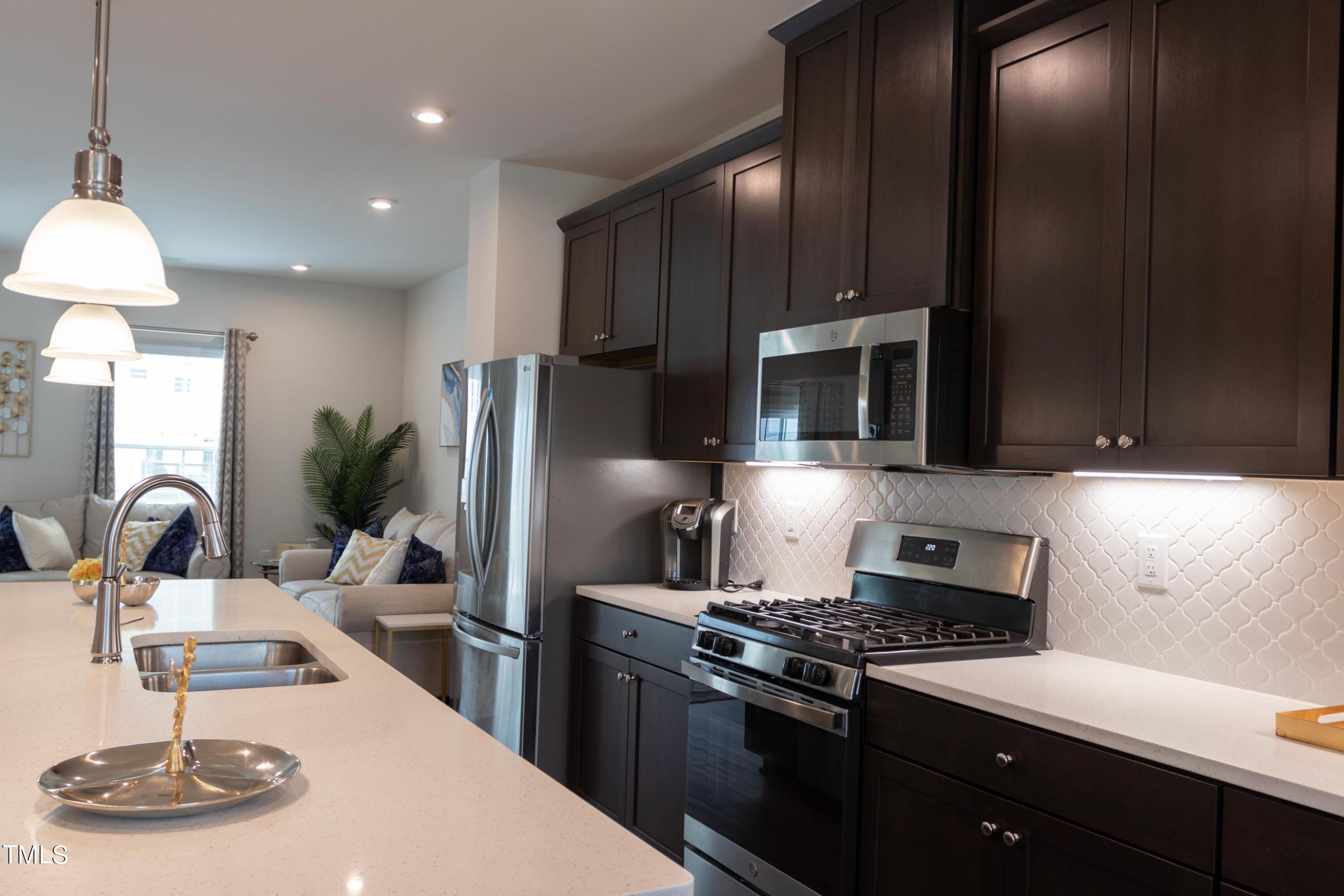 1505 Newpoint Drive Durham, NC 27713 - Photo 3 of 48 a kitchen with kitchen island granite countertop a sink stainless steel appliances and cabinets