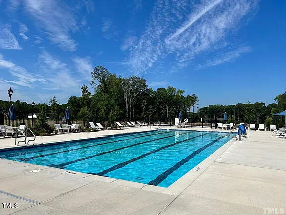 1505 Newpoint Drive Durham, NC 27713 - Photo 47 of 48 a view of swimming pool with seating space and trees in the background