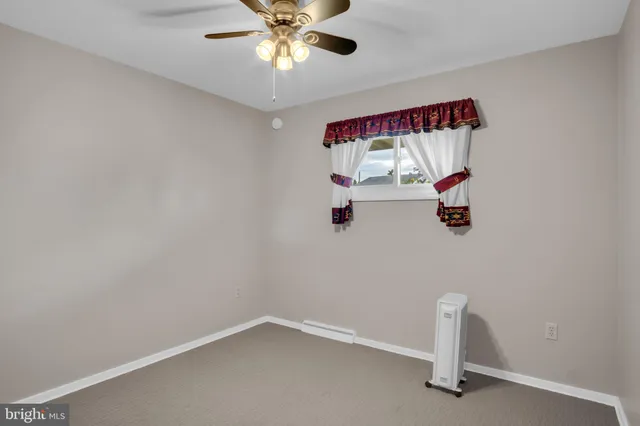 a view of empty room with a ceiling fan