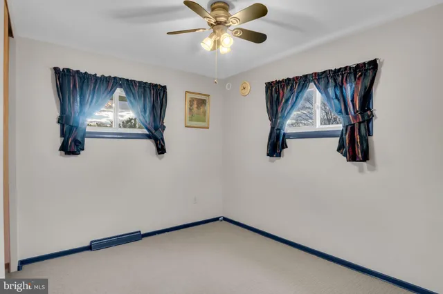 a view of an empty room with a chandelier fan
