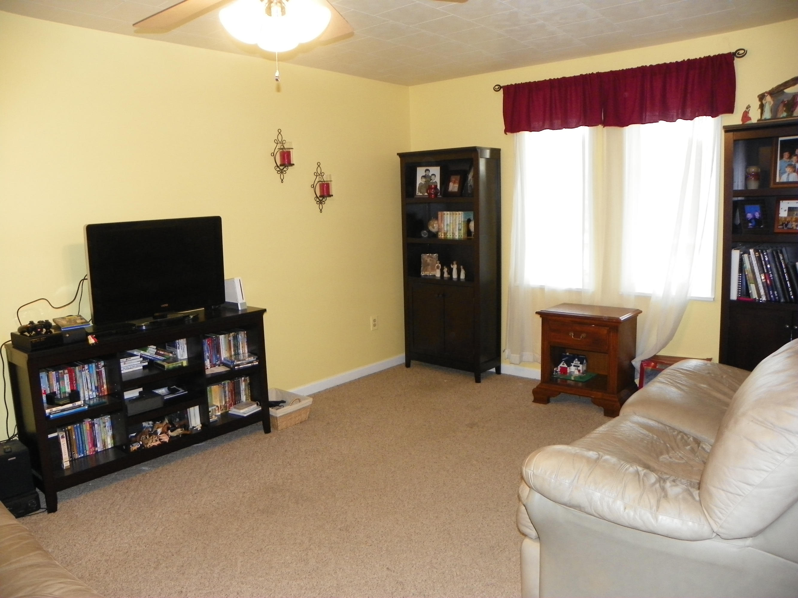 327 Clemons Road Roanoke, VA 24019 - Photo 18 of 35 a living room with furniture a flat screen tv and a floor to ceiling window
