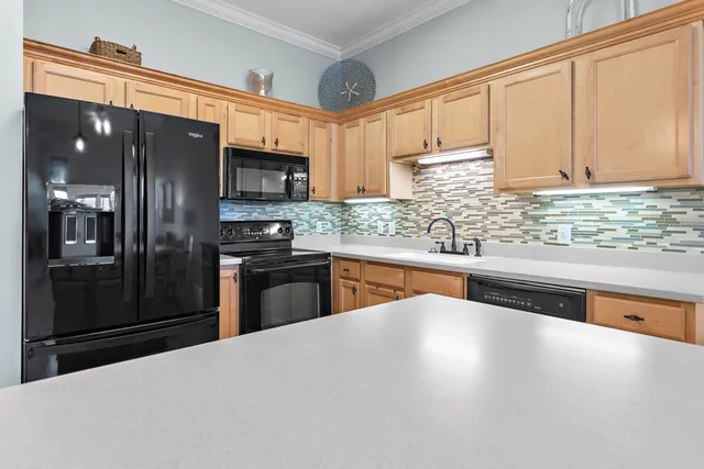 a kitchen with kitchen island granite countertop a sink stove and refrigerator