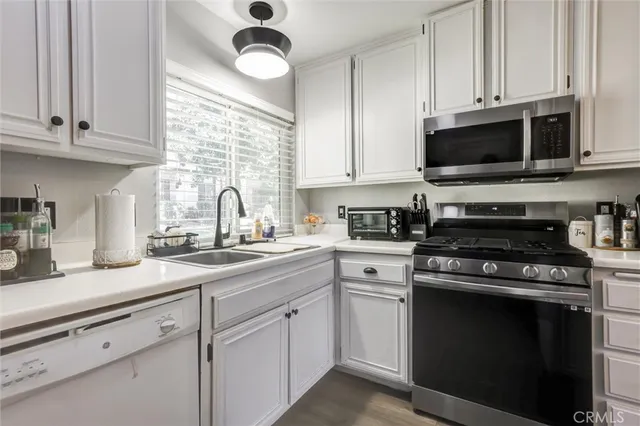 a kitchen with cabinets stainless steel appliances and a sink