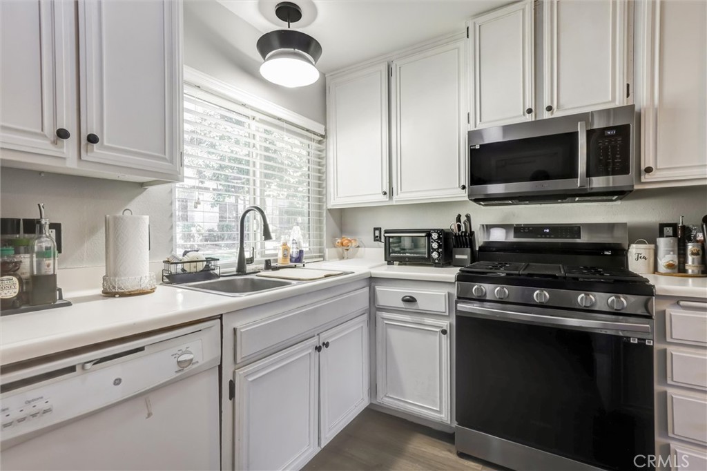a kitchen with cabinets stainless steel appliances and a sink