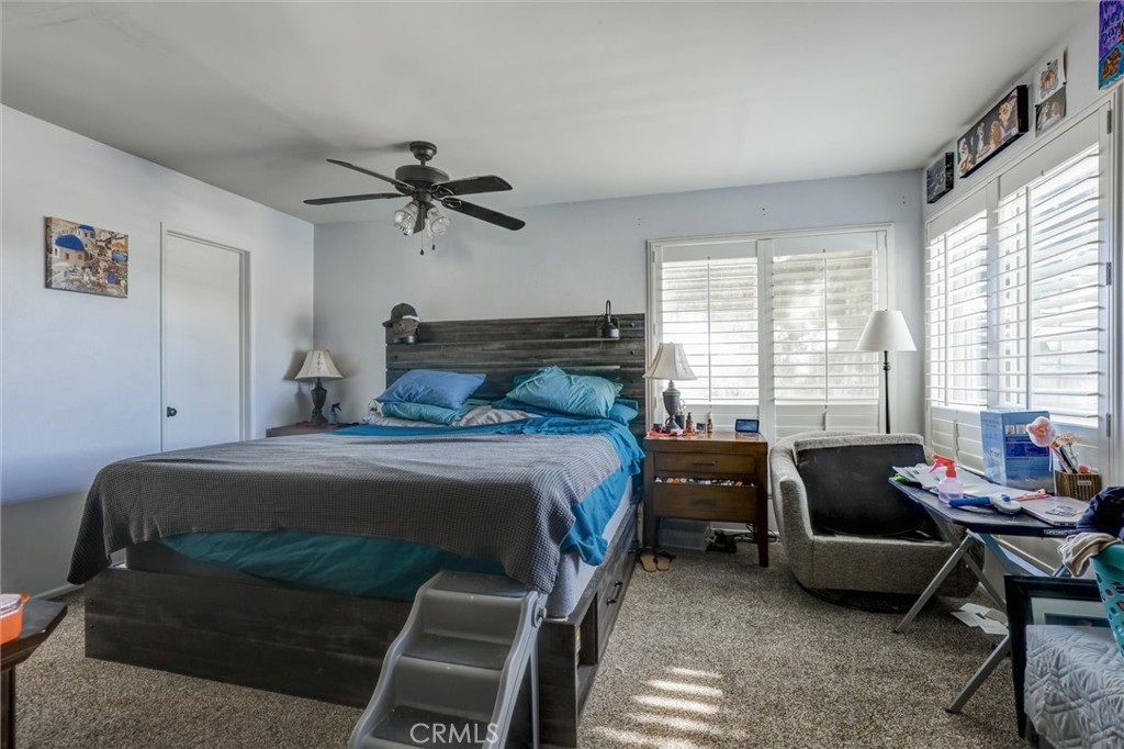 4687 Knickerbocker Lane Riverside, CA 92501 - Photo 11 of 27 a bedroom with a bed and a chandelier