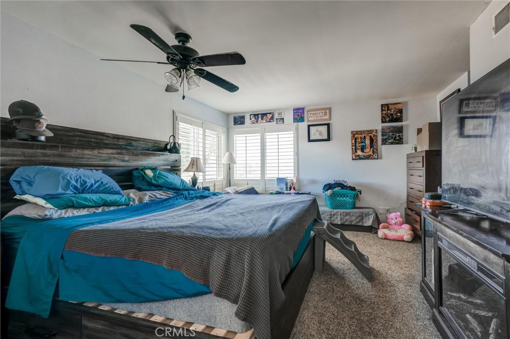4687 Knickerbocker Lane Riverside, CA 92501 - Photo 14 of 27 a bed room with a bed and a ceiling fan