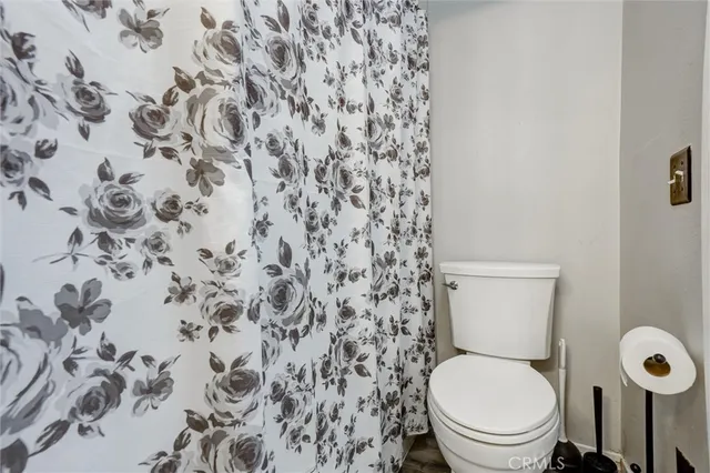 a white toilet sitting next to a shower curtain
