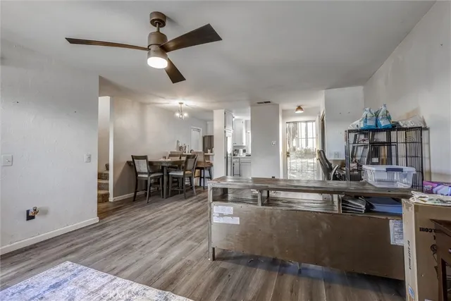 a living room with furniture kitchen view and a wooden floor