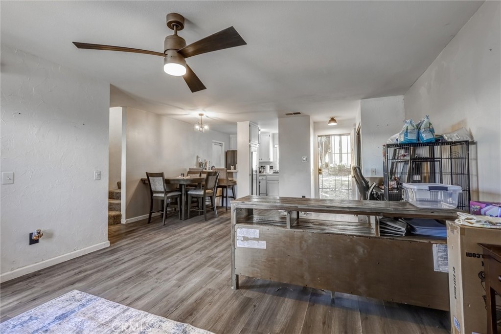 4687 Knickerbocker Lane Riverside, CA 92501 - Photo 4 of 27 a living room with furniture kitchen view and a wooden floor