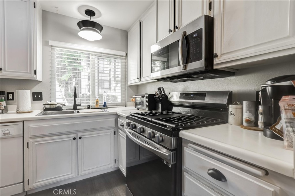 4687 Knickerbocker Lane Riverside, CA 92501 - Photo 6 of 27 a kitchen with cabinets appliances a sink and a window
