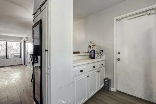a hallway with white cabinets and wooden floor