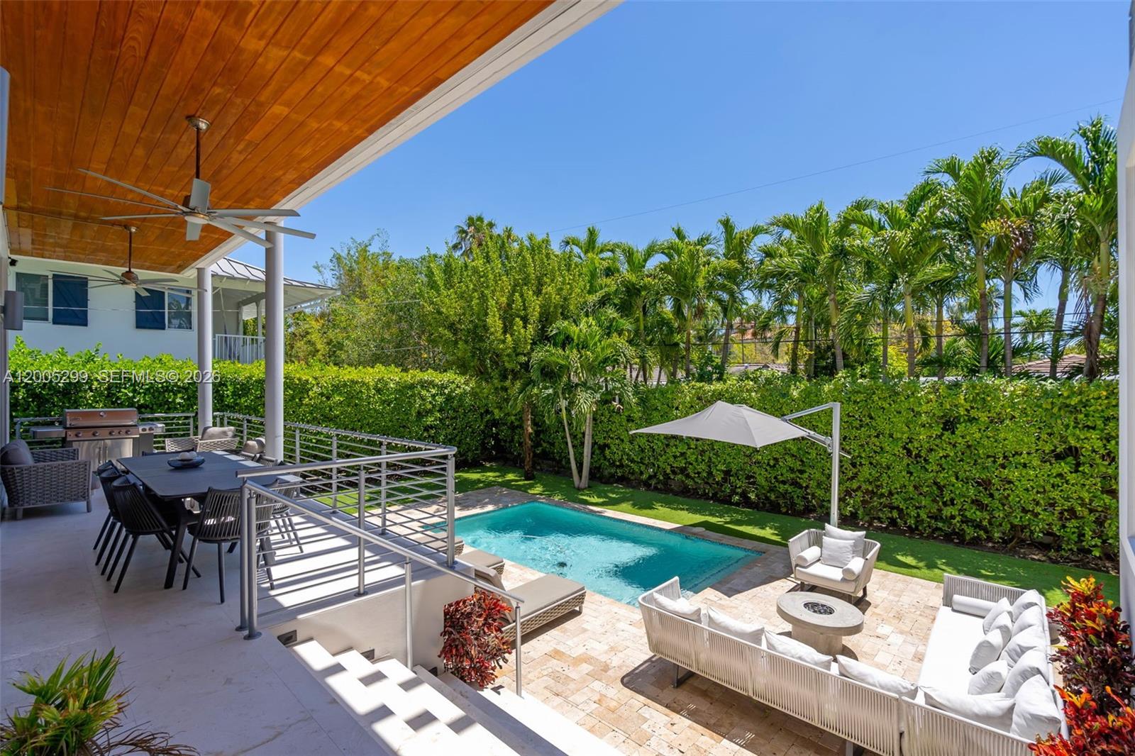 230 West McIntyre Street Key Biscayne, FL 33149 - Photo 2 of 53 a view of a table and chairs under an umbrella