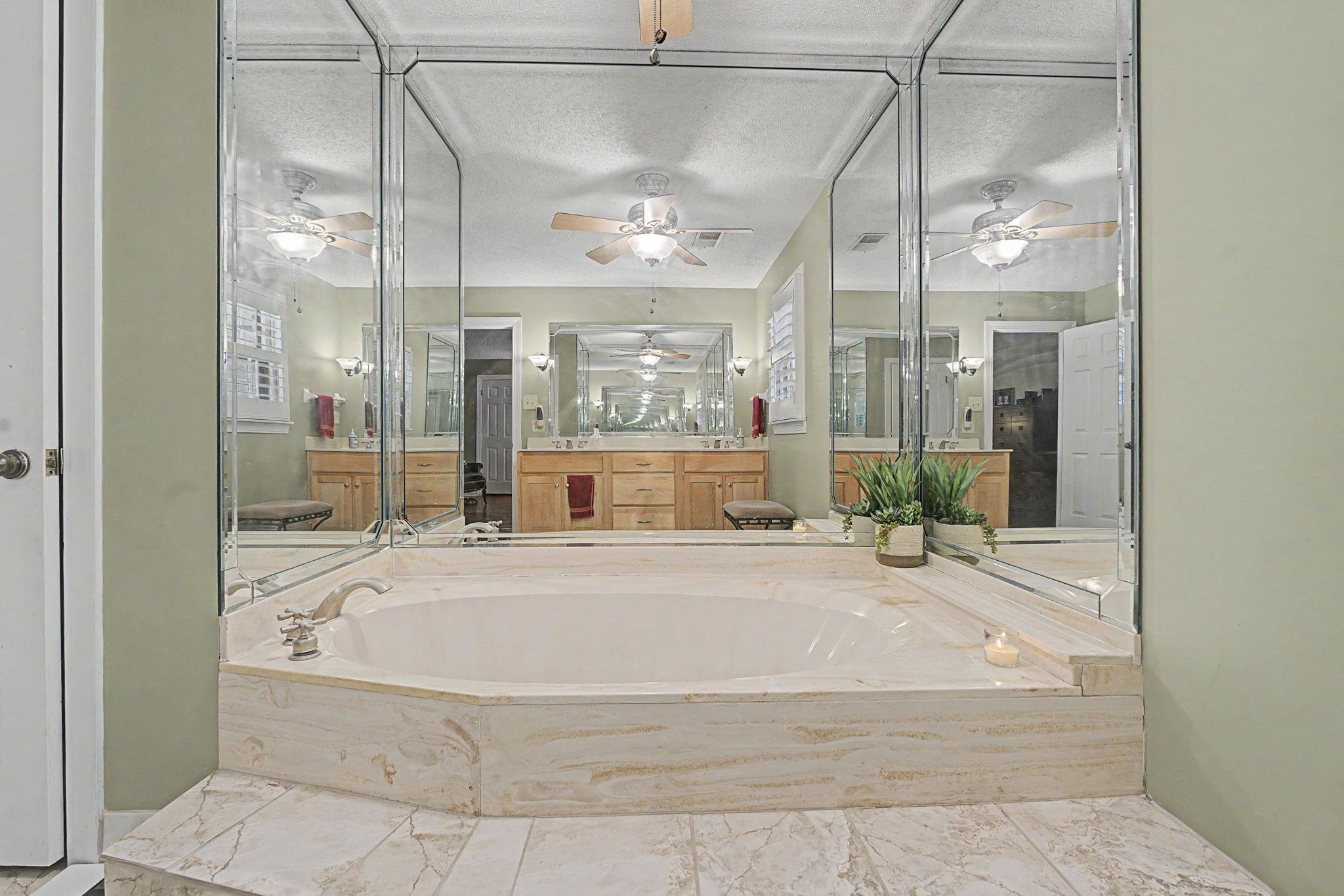 1929 Miller Farms Road Germantown, TN 38138 - Photo 22 of 40 Built-in soaking tub with a light-toned stone surround and matching tile flooring