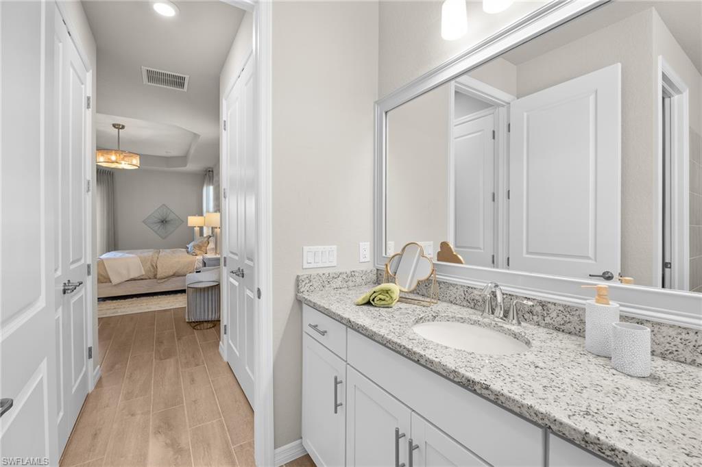 15048 Redbud Lane Punta Gorda, FL 33955 - Photo 20 of 34 a en suite bathroom with a granite countertop sink and a mirror