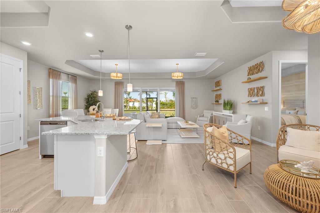 15048 Redbud Lane Punta Gorda, FL 33955 - Photo 3 of 34 a large kitchen with stainless steel appliances a large counter top a couch and a view of living room