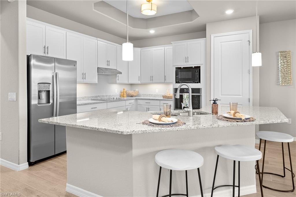 15048 Redbud Lane Punta Gorda, FL 33955 - Photo 7 of 34 a kitchen with stainless steel appliances granite countertop a sink a stove a refrigerator and white cabinets with wooden floor