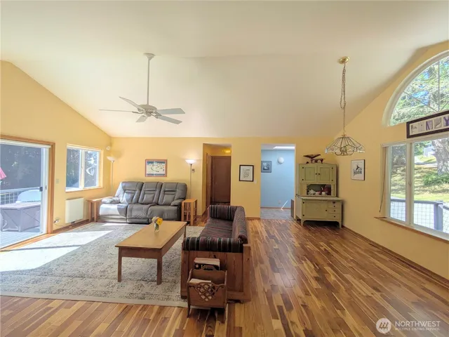 a living room with furniture a chandelier and a wooden floor