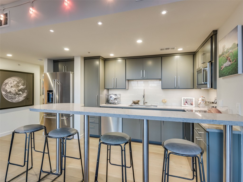 54 Rainey Street, Unit 922 Austin, TX 78701 - Photo 17 of 24 a kitchen with cabinets table and chairs