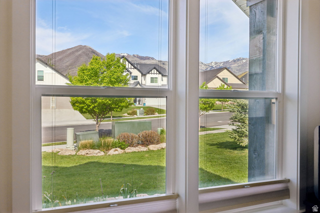 1238 Canyon View Road Midway, UT 84049 - Photo 16 of 36 Double-hung windows featuring white frames, a distant mountain range, and a landscaped foreground with mature trees and green lawn