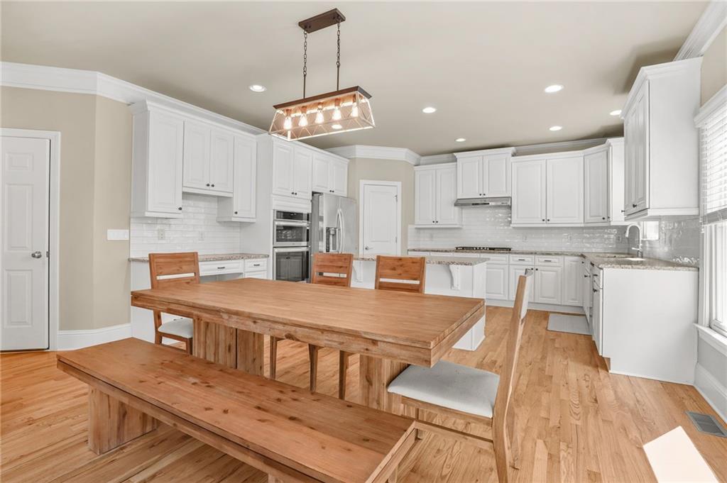 955 Gardiner Circle Suwanee, GA 30024 - Photo 11 of 44 a large kitchen with kitchen island a large island in white appliances