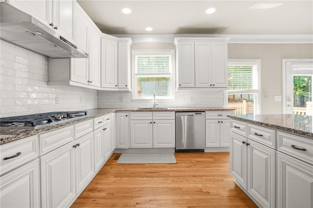 955 Gardiner Circle Suwanee, GA 30024 - Photo 13 of 44 a kitchen with granite countertop white cabinets and white appliances