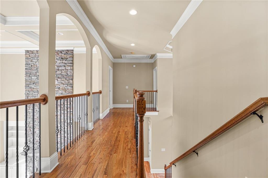 955 Gardiner Circle Suwanee, GA 30024 - Photo 21 of 44 a view of a hallway with wooden floor and staircase