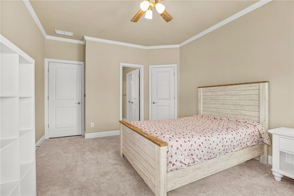 955 Gardiner Circle Suwanee, GA 30024 - Photo 30 of 44 a room with a bed and a chandelier