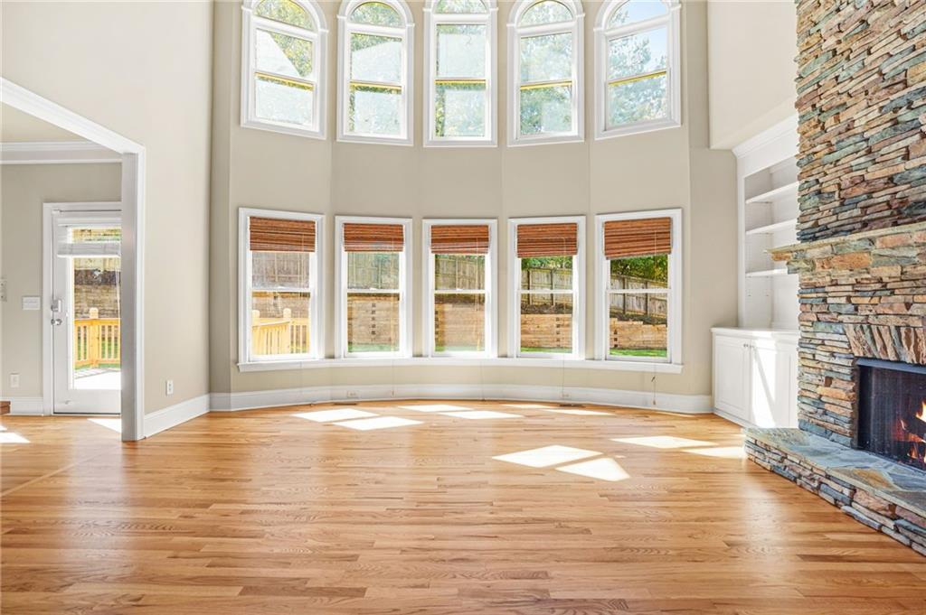 955 Gardiner Circle Suwanee, GA 30024 - Photo 7 of 44 a view of empty room with a fireplace and wooden floor
