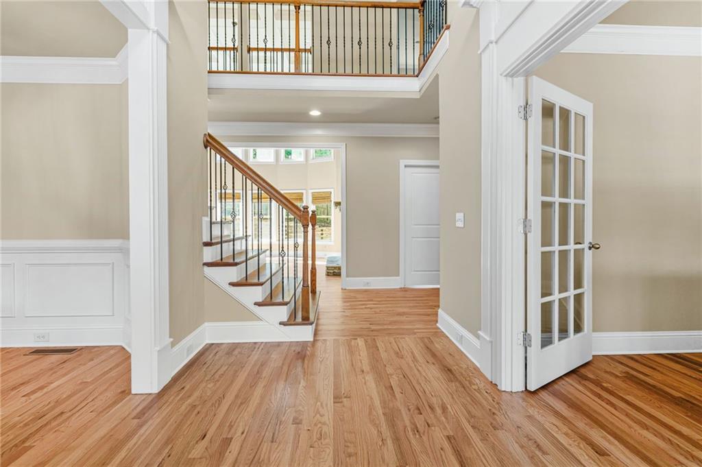 955 Gardiner Circle Suwanee, GA 30024 - Photo 8 of 44 a view of a hallway with wooden floor and staircase