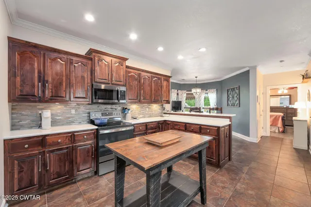 a kitchen with a stove a sink refrigerator and a microwave