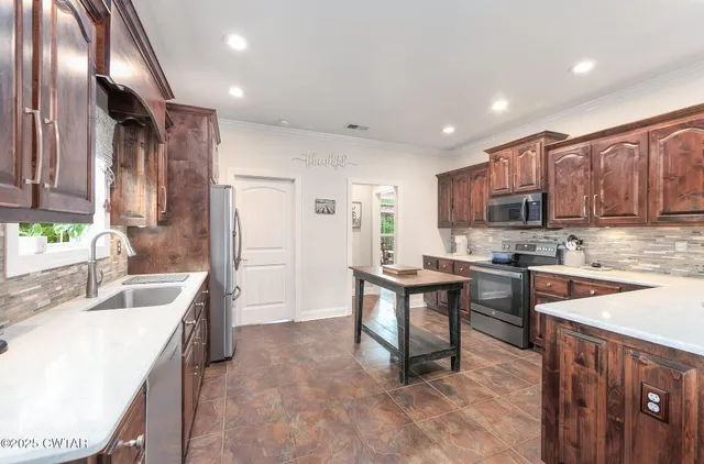 a kitchen with stainless steel appliances granite countertop a sink stove and refrigerator