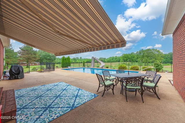 a patio with glass top table and chairs