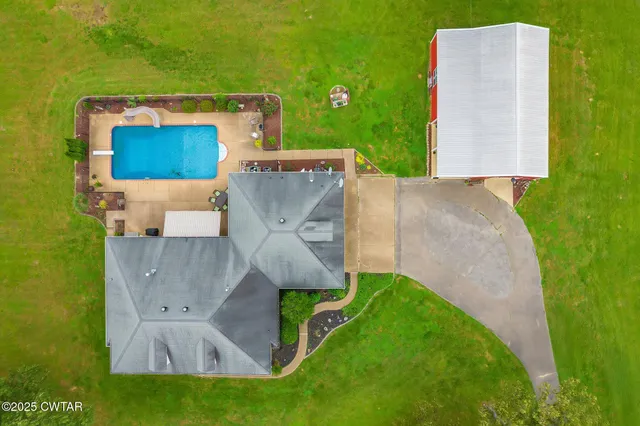 an aerial view of a house with pool and garden