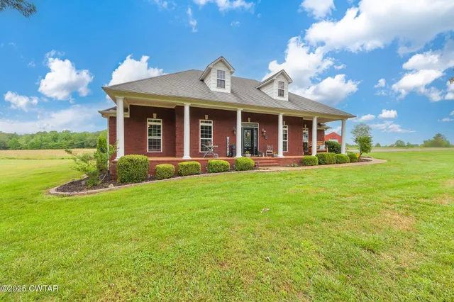 a front view of a house with garden and lake view
