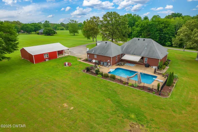an aerial view of a house with swimming pool garden and outdoor seating