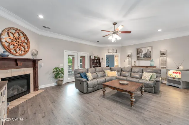 a living room with furniture a fireplace and a ceiling fan